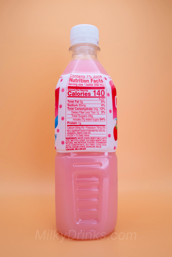 Calpico Strawberry drink bottle with nutrition label in display, on a peach background