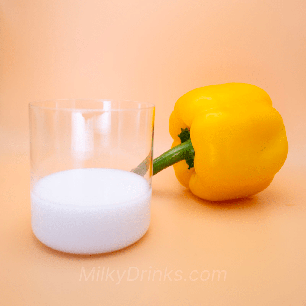 Milky white Bourbon Oishii Coconut Milk drink in a glass with a pepper and peach background